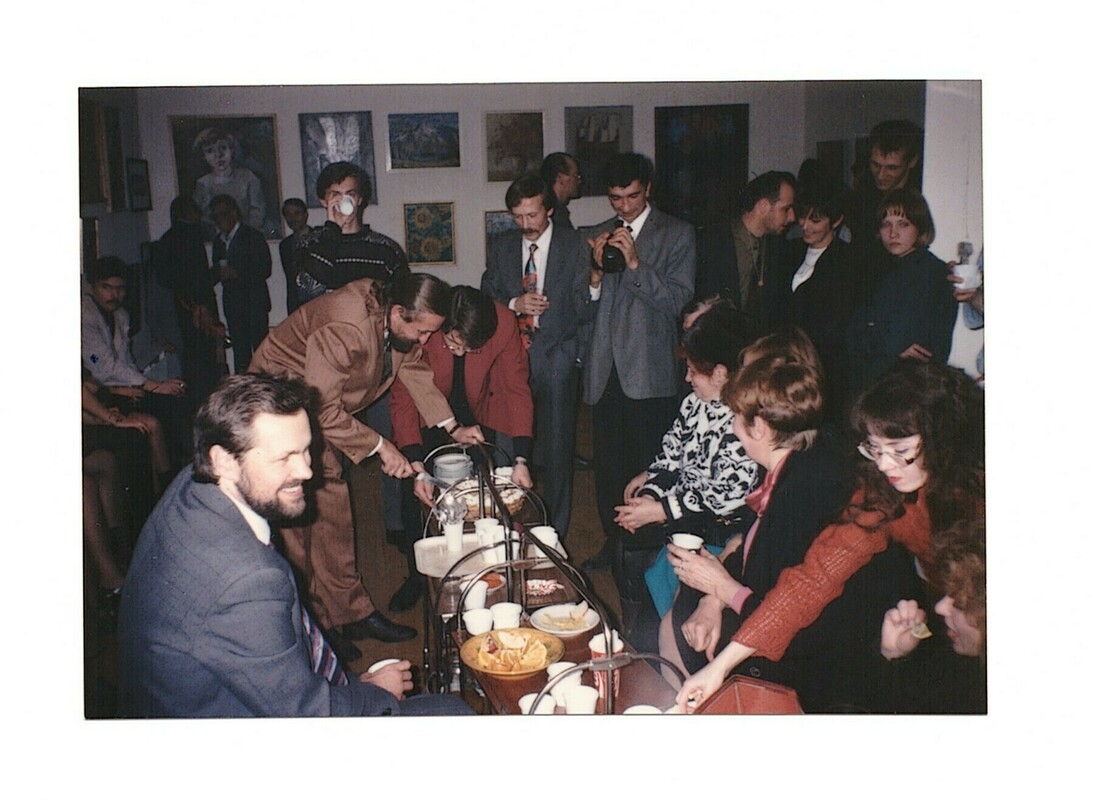 A crowded gathering around a tea table at Gallery M in Apatity in 1996
